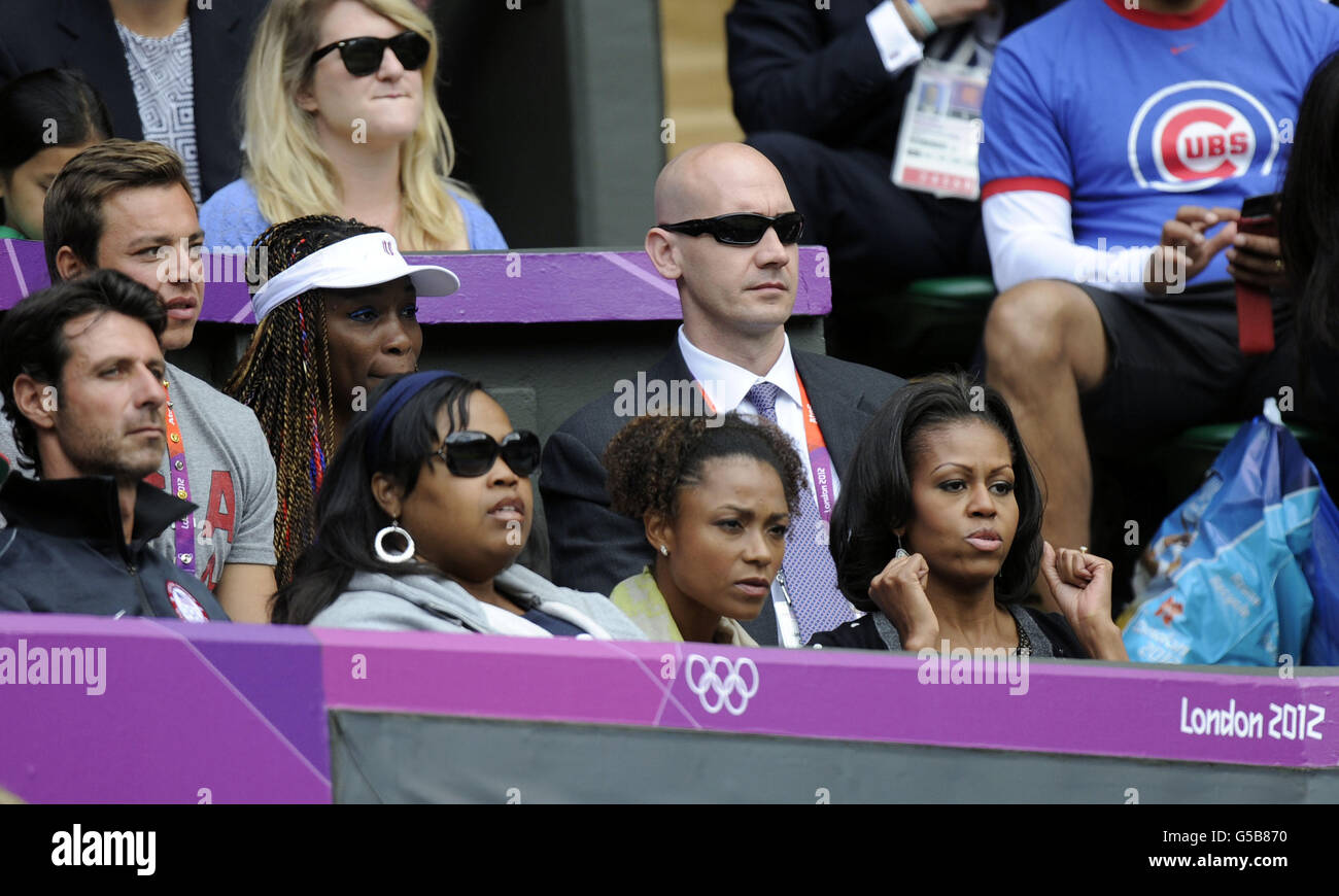 First Lady Michelle Obama (all'estrema destra) guarda la Serena Williams degli Stati Uniti in azione durante il primo round del Women's Singles presso il campo da tennis olimpico di Wimbledon. Foto Stock