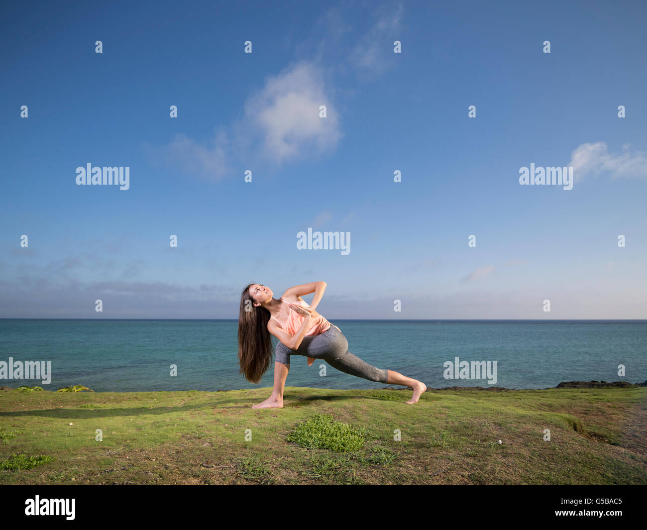Giovane donna a praticare yoga sulla spiaggia di Motobu, Okinawa, in Giappone Foto Stock