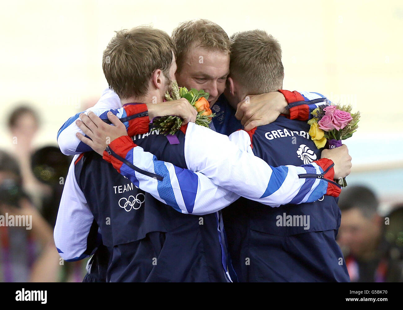 Giochi Olimpici di Londra - 6° giorno. Chris Hoy, Sir della Gran Bretagna, abbraccia Jason Kenny (a sinistra) e Philip Hindes dopo la cerimonia di vittoria del Men's Team Sprint. Foto Stock