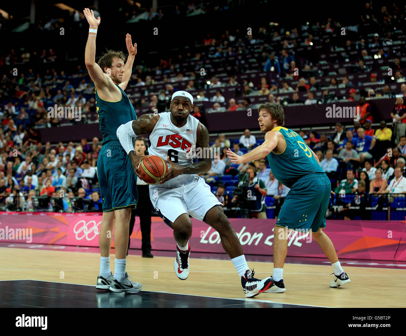 Lebron James degli Stati Uniti in azione contro Matt Dellavedova dell'Australia (a destra) e Joe Ingles (a sinistra) nella partita di pallacanestro dei Mens quarterfinal alla North Greenwich Arenas il giorno 12 dei Giochi Olimpici di Londra 2012. Foto Stock