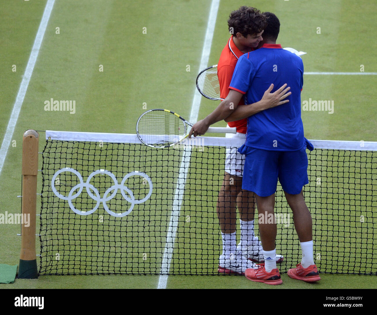 Il francese Jo-Wilfred Tsonga abbraccia Milos Raonic canadese dopo aver vinto la partita con il più lungo set nella storia olimpica, 25-23, nel secondo round dei singoli uomini alla sede olimpica di tennis di Wimbledon. Foto Stock