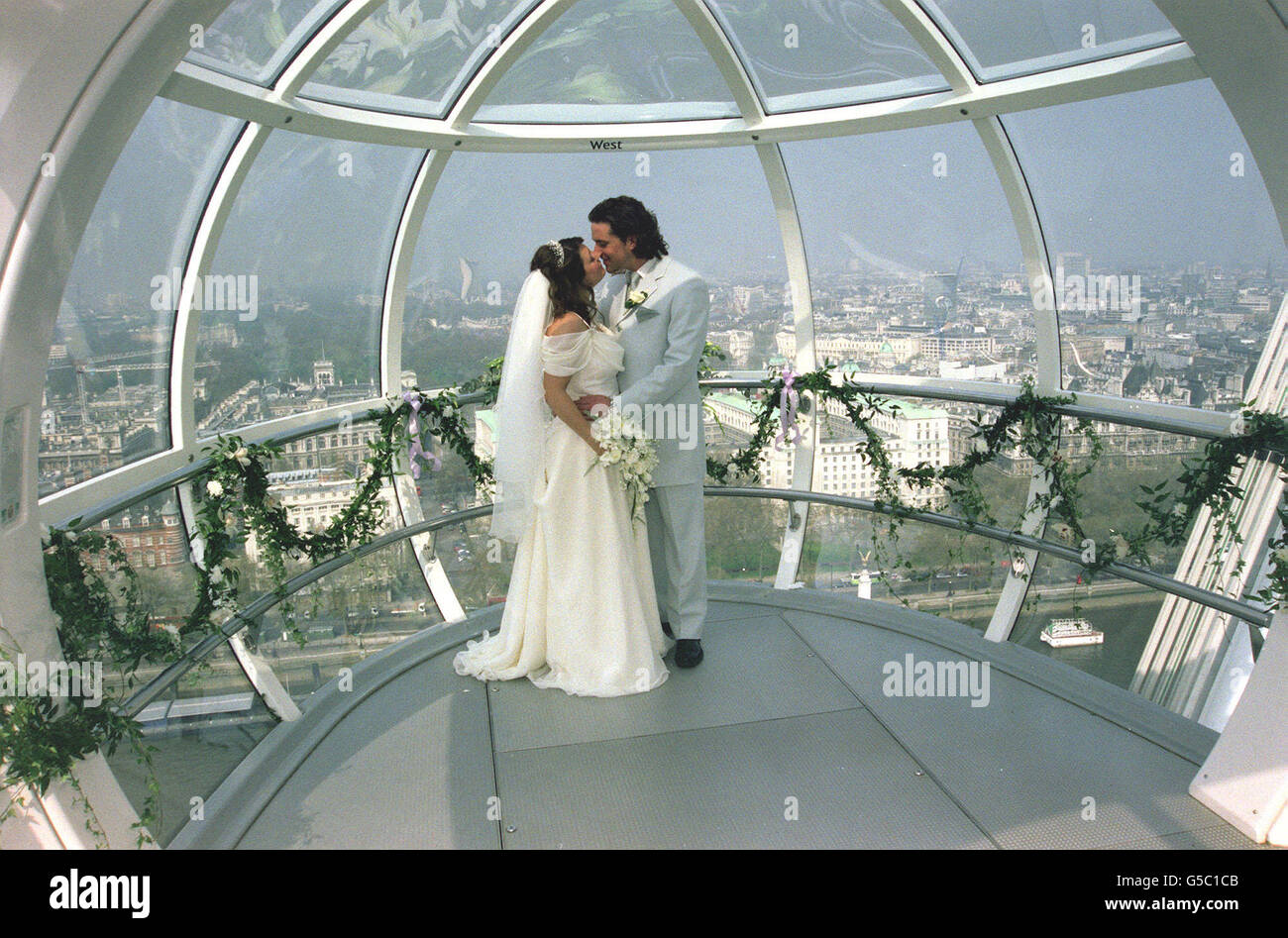 Simon Stapleton, 31 anni, e Dawn Bottomley, 26 anni, dopo aver scambiato voti in uno dei Millennium Eye's pod, 450ft sopra Londra. La coppia, da Burgess Hill, West Sussex, divenne la prima coppia a sposarsi al volante. * dopo aver vinto un concorso sul programma televisivo del mattino GMTV. La cerimonia civile di 15 minuti, condotta dal registrar del sovrintendente Lambeth, Richard Edwards, si è svolta con vista spettacolare di Londra in quello che si pensa sia il giorno più caldo dell'anno finora. Foto Stock