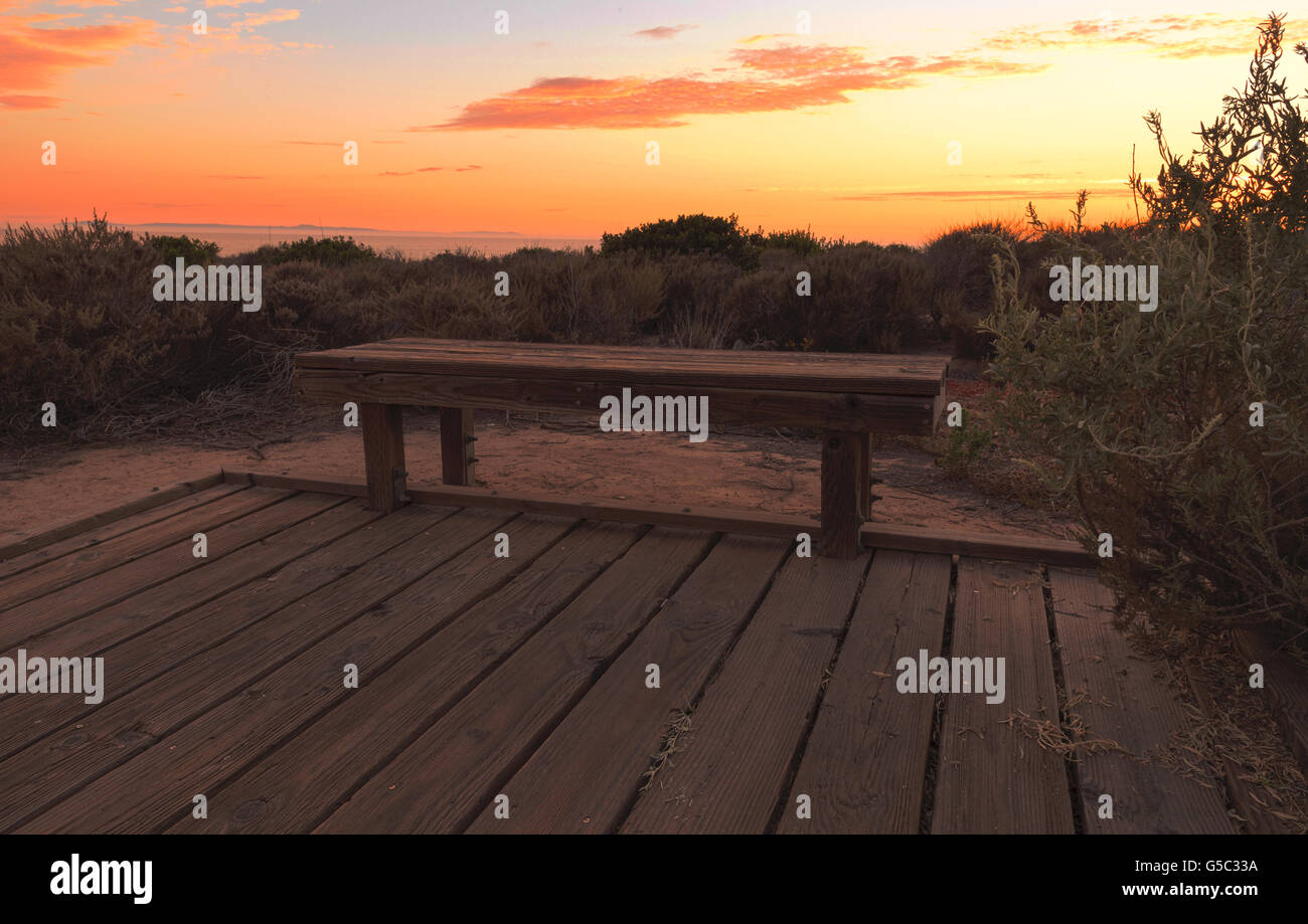 Il Boardwalk panca al Crystal Cove Beach al tramonto in estate Foto Stock