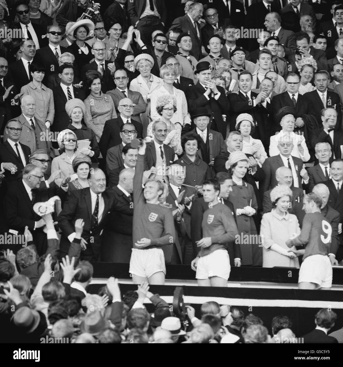 La regina sorride e scuote le mani con Bobby Charlton dopo aver presentato la sua medaglia dopo la vittoria dell'Inghilterra del 4-2 sulla Germania occidentale nella finale della Coppa del mondo a Wembley. Foto Stock