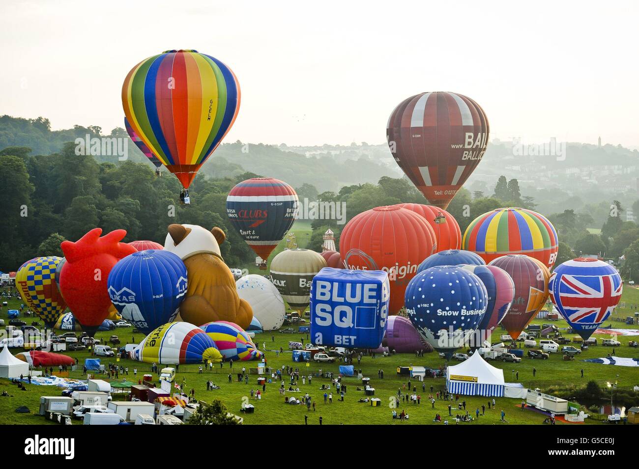 I mongolfiere decolla sopra Ashton Court durante una salita di massa alla 34esima edizione della fiera internazionale di mongolfiera di Bristol, Ashton Court Estate, mentre i mongolfiere provenienti da tutto il mondo si riuniscono in quello che è il più grande evento di mongolfiera in Europa. Foto Stock