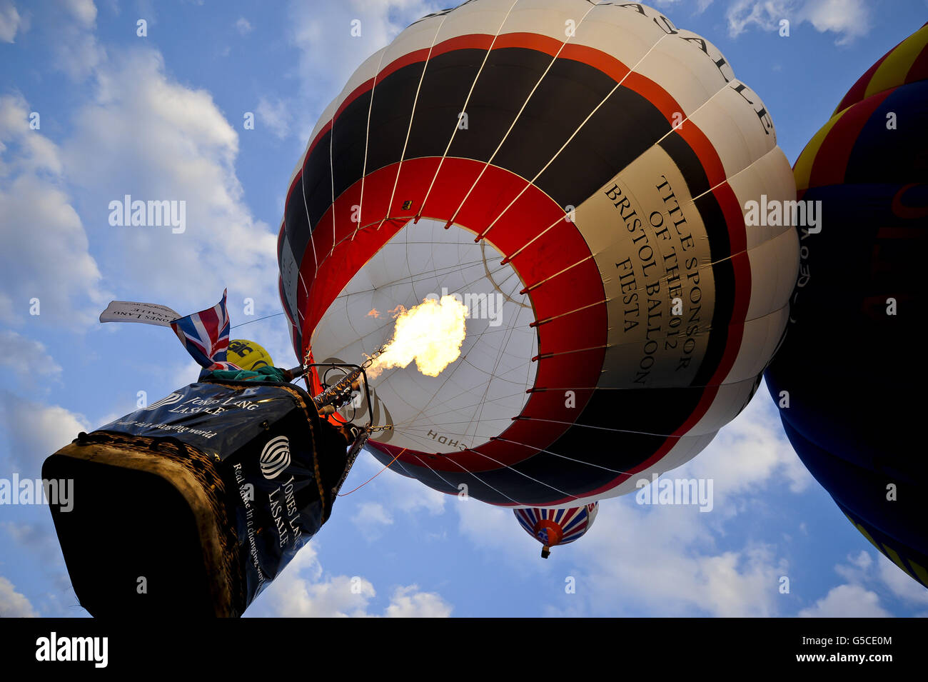 Una mongolfiera decollo sopra Ashton Court durante una salita di massa alla 34esima edizione della fiera internazionale della mongolfiera di Bristol, Ashton Court Estate, mentre i mongolfiere provenienti da tutto il mondo si riuniscono in quello che è il più grande evento di mongolfiera in Europa. Foto Stock