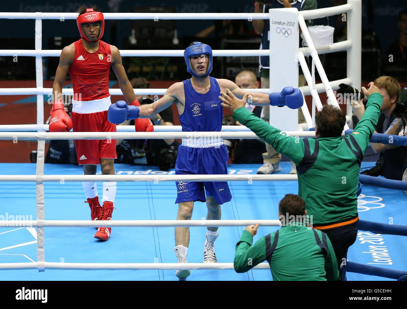 John Joe Nevin (blu) d'Irlanda festeggia con gli allenatori Billy Walsh e Zaur Anita dopo aver vinto il suo but con Lazaro Alvarez Estrada di Cuba nella loro lotta uomo Boxing Bantam-weight 56 kg alla Excel Arena di Londra durante i Giochi Olimpici di Londra 2012 Foto Stock