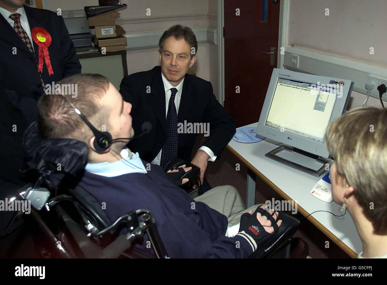 Il primo Ministro Tony Blair incontra Luke Bryan al Centro di comunicazione per l'Educazione di Watersheddings, Oldham. Luke, di 21 anni, confinato su una sedia a rotelle, ha mostrato come utilizza la tecnologia di riconoscimento vocale. * ...per comunicare con il mondo più ampio. Foto Stock