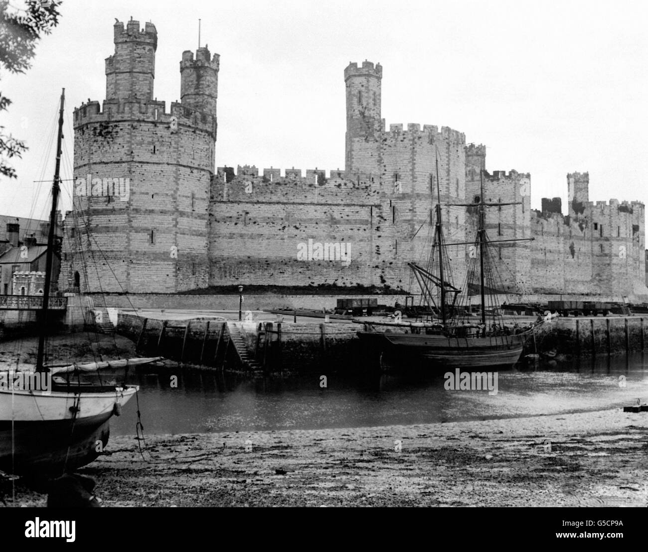 Una vista edoardiana del castello di Caernarvon nel Galles del Nord, parte della catena di fortificazioni costruite dal re inglese Edoardo i nel 13 ° secolo per soggiogare il gallese ribelle. L'architettura fu influenzata dalle mura teodosiane di Costantinopoli. Foto Stock