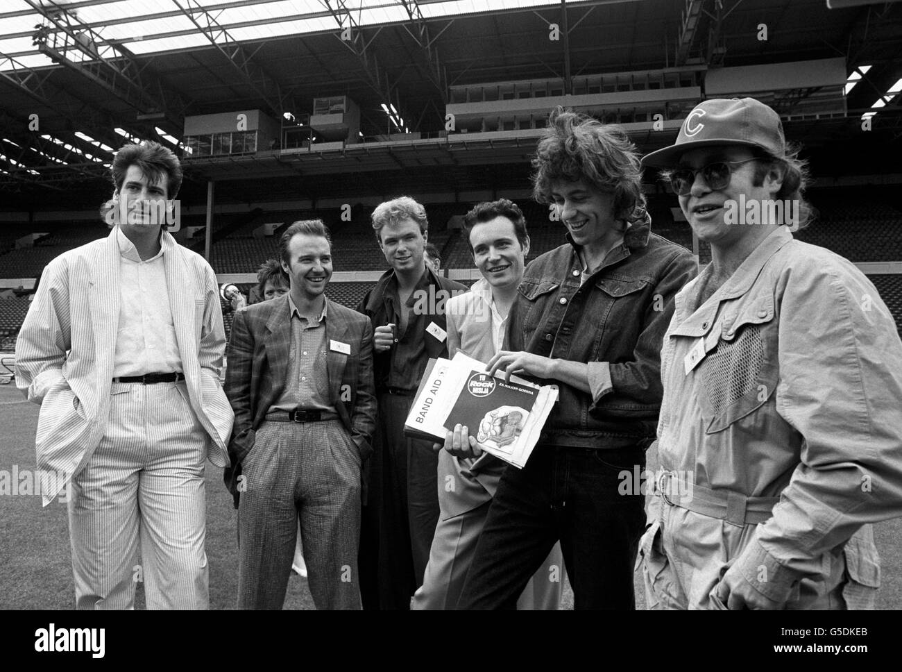 BAND AID 1985: Rock star allo stadio di Wembley, Londra, dopo l'annuncio che Band Aid è il palco del più grande evento rock che il mondo abbia mai visto per raccogliere milioni di persone per il fascino della carestia etiope. (l-r) Tony Hadley, Midge Ure, Gary Kemp, Adam ANT, Bob Geldof ed Elton John. *19/12/01: Stelle rock allo stadio di Wembley, Londra, in seguito all'annuncio che Band Aid sta per mettere in scena il più grande evento rock che il mondo abbia mai visto per raccogliere milioni di persone per l'appello della carestia etiope. (l-r) Tony Hadley, Midge Ure, Gary Kemp, Adam ANT, Bob Geldof ed Elton John. Fu annunciato che Wembley avrebbe fatto Foto Stock