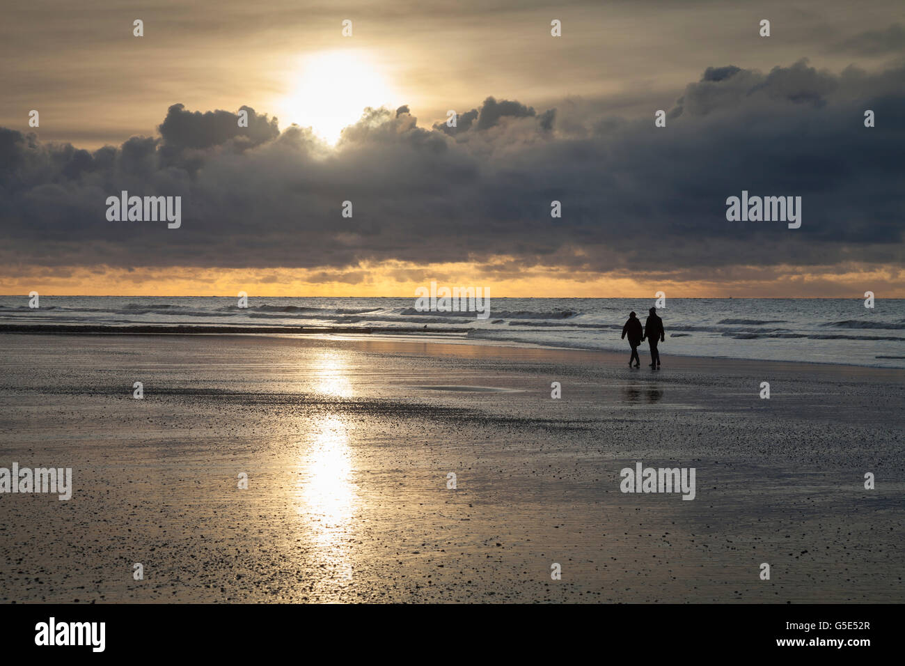 Walkers a costa, luce della sera, al tramonto con nuvole, Norderney, Est Frisone Isola, Frisia orientale, Bassa Sassonia, Germania Foto Stock