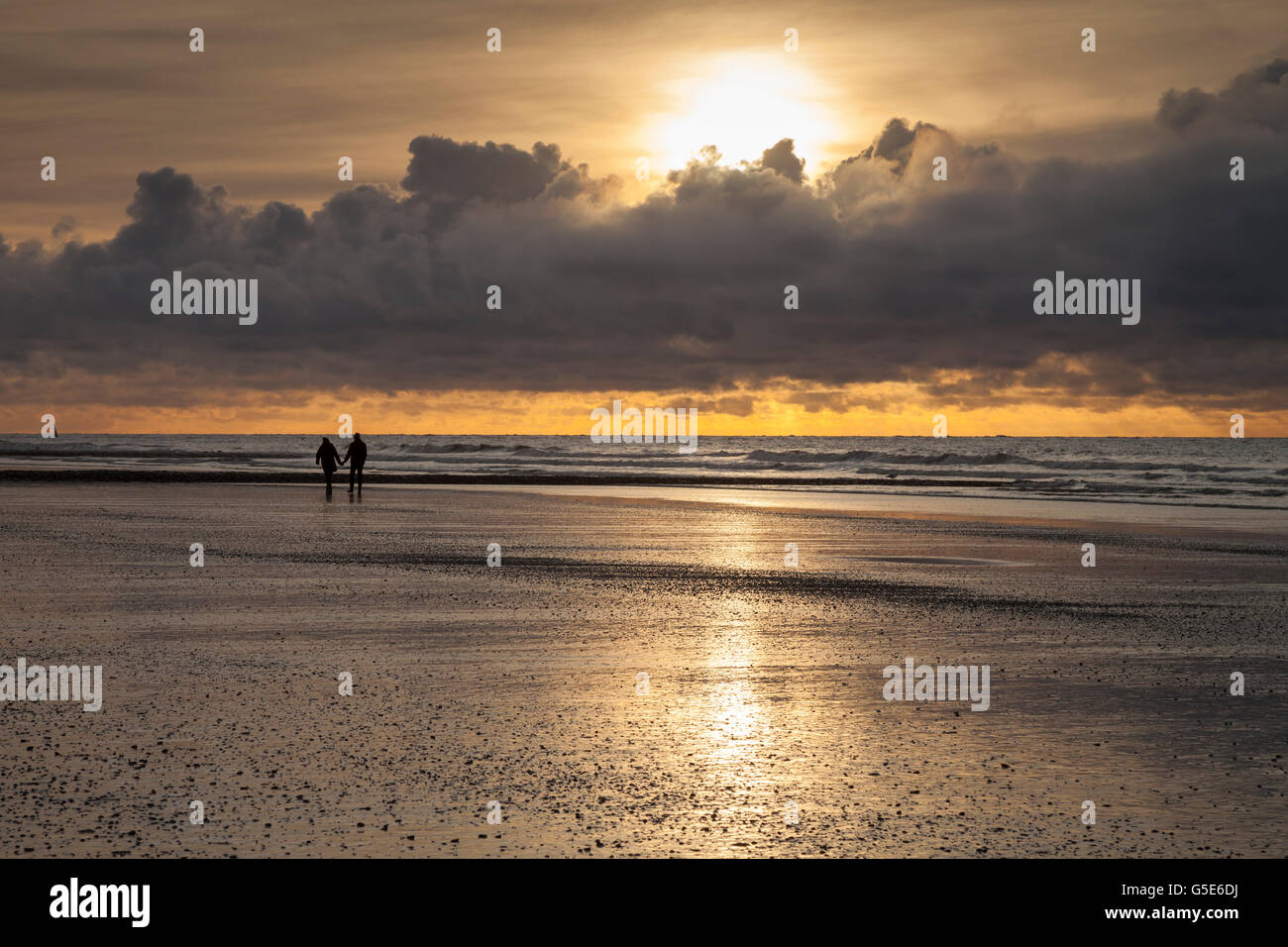 Walkers a costa, luce della sera, al tramonto con nuvole, Norderney, Est Frisone Isola, Frisia orientale, Bassa Sassonia, Germania Foto Stock