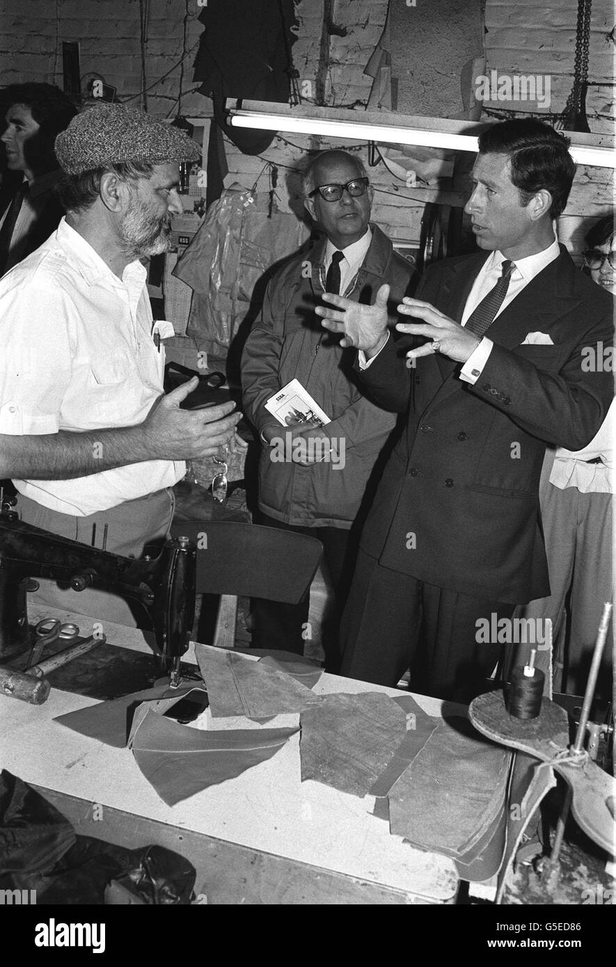 Il Principe del Galles con Hashim Siddique (L), proprietario di un'officina in pelle, presso la sua sede a Hanbury Street, nell'East End di Londra. Foto Stock