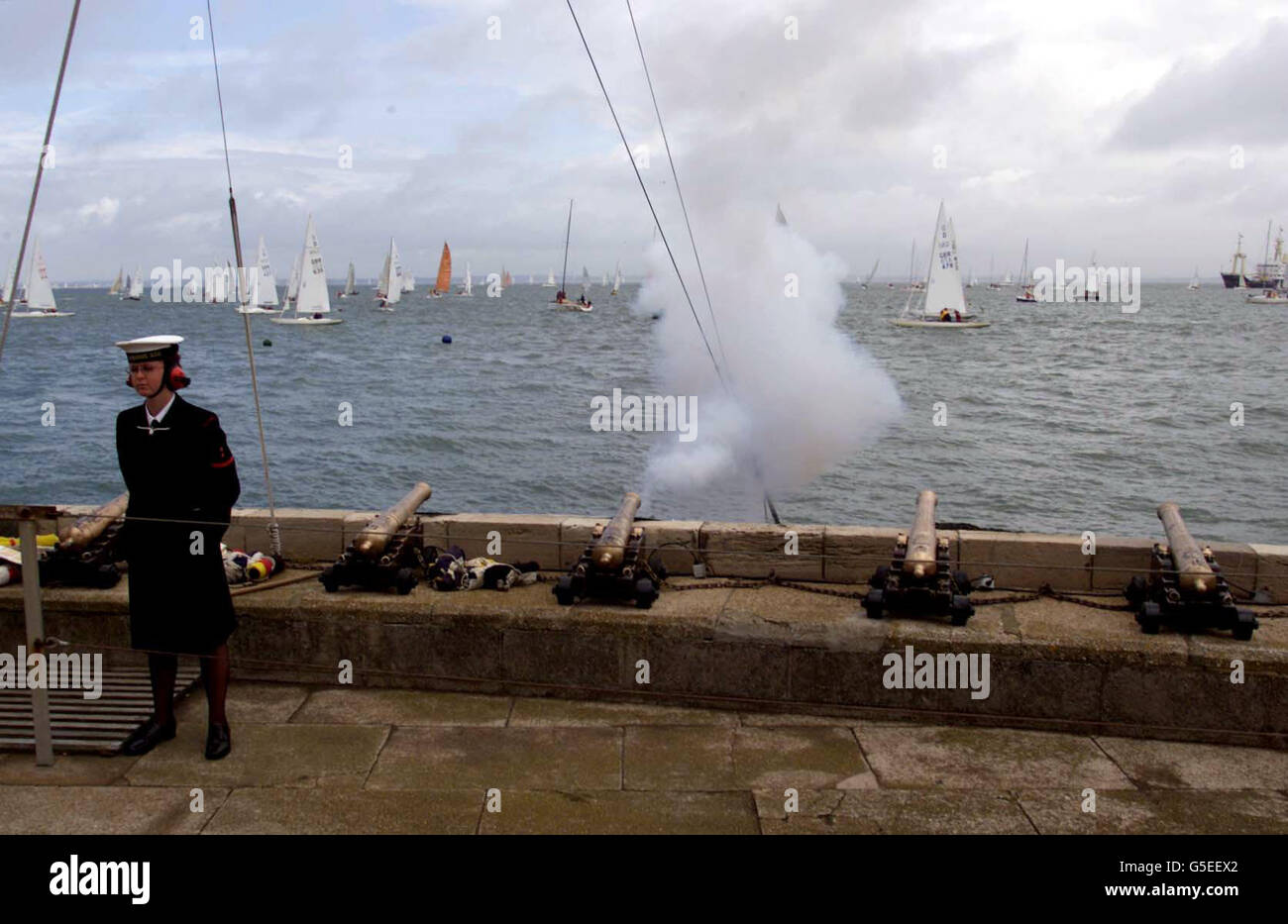 Il cannone di partenza spara dal Royal Yacht Squadron a Cowes, Isola di Wight, per segnalare l'inizio delle corse il terzo giorno della settimana dei Cowes. Foto Stock