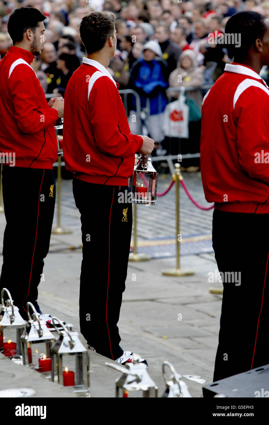 I giocatori della Liverpool Academy lasciano le candele all'altopiano di St George's, mentre migliaia di persone si sono riunite stasera a St George's Place nel centro di Liverpool per una veglia in memoria delle 96 vittime del disastro di Hillsborough. Foto Stock