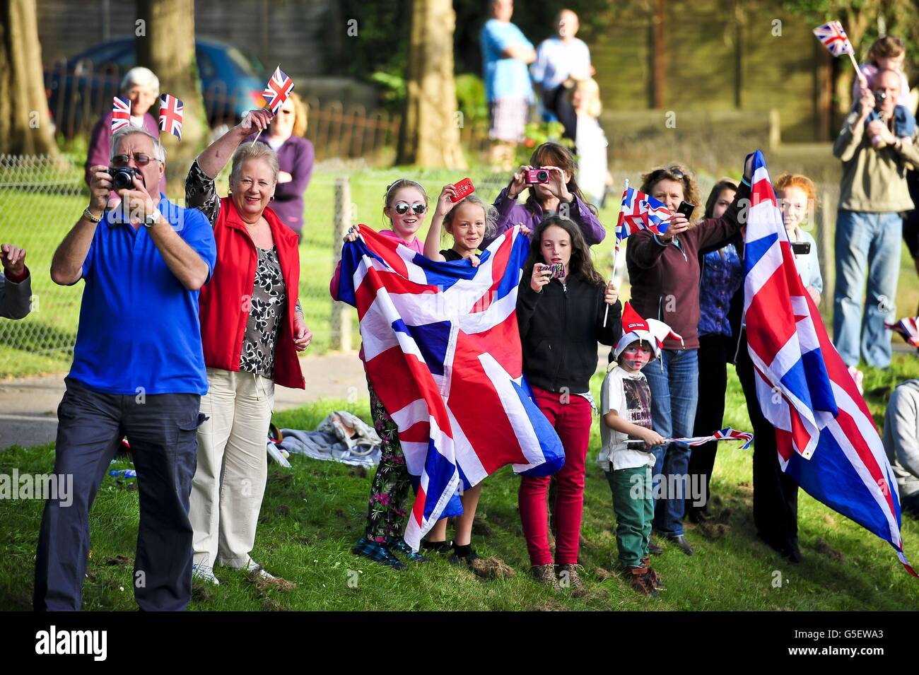 I tifosi ondeggiano Union Flags mentre guardano gli atleti olimpici e paralimpici di Plymouth a bordo di un autobus scoperto mentre attraversano le strade di Plymouth, dove migliaia di persone hanno scoperto di accoglierli a casa dai giochi. Foto Stock