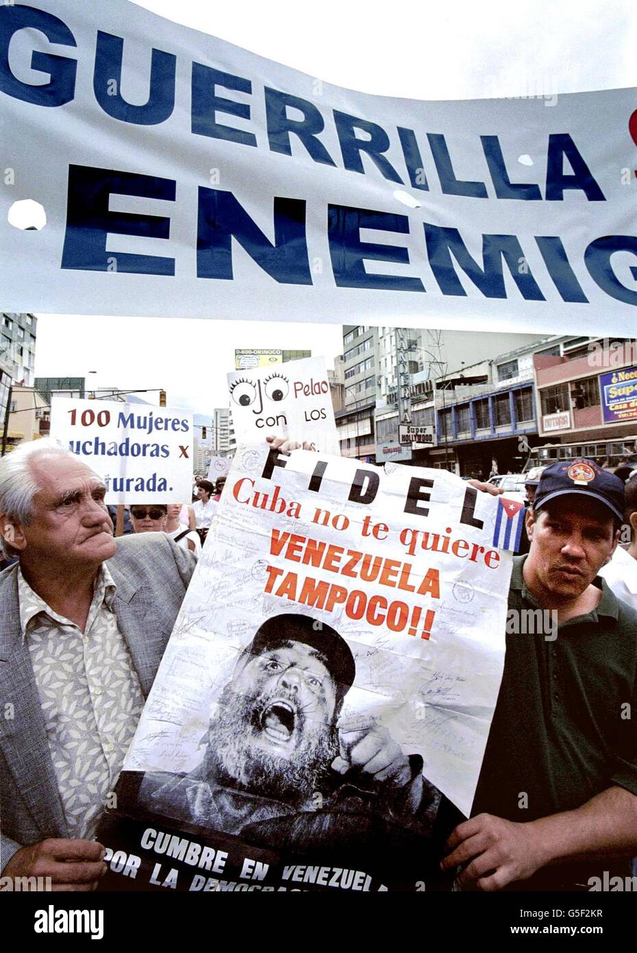 I dimostranti di manifestare contro il governo venezuelano mentre trasporta un poster del leader cubano Fidel Castro durante una manifestazione di protesta nella città di Caracas, 23 giugno 2001. I dimostranti sono stati la dimostrazione contro i criteri di scambio tra Cuba e Venezuela. (Pellicola) AFP PHOTO/Evel GONZALEZ Foto Stock
