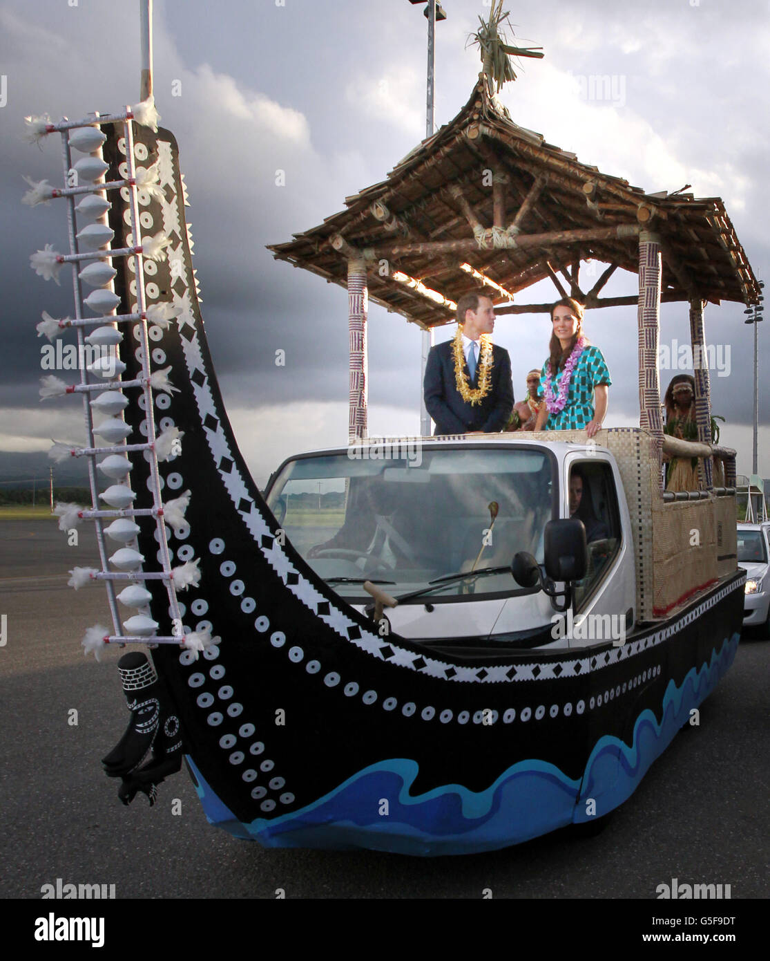 Il Duca e la Duchessa di Cambridge su un veicolo scoperto, a forma di canoa tradizionale con tetto a balestra quando partono dall'aeroporto di Henderson, Honiara, Isole Salomone, durante il tour reale di nove giorni dell'Estremo Oriente e del Sud Pacifico in onore del Giubileo dei Diamanti della Regina. Foto Stock