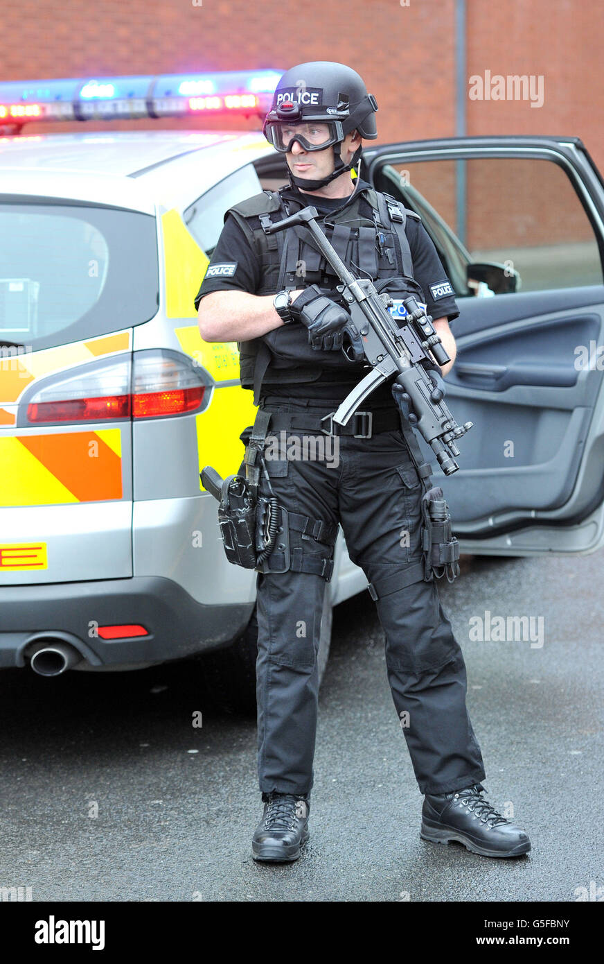 La polizia armata è custodita mentre un pulmino di polizia credeva di portare Dale Cregan (non raffigurato) arriva alla prigione di Manchester, dopo essere apparso alla Manchester Crown Court accusato di quattro omicidi, tra cui l'attacco di sparo e granata che ha ucciso due poliziotti. Foto Stock