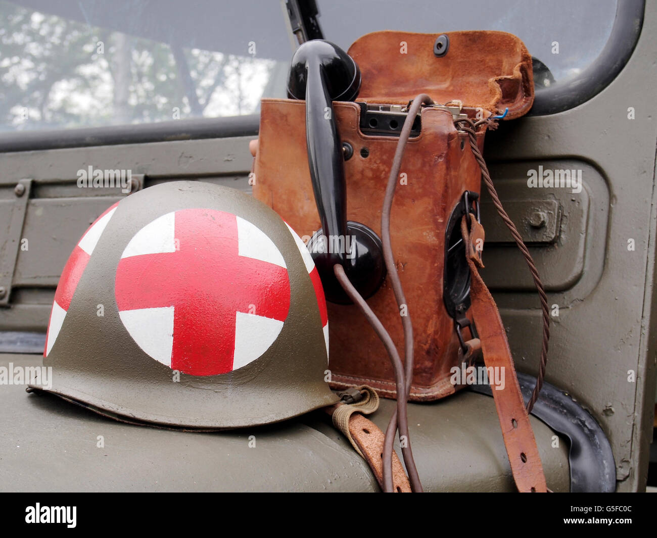 WW2 US Army medics acciaio casco e un campo telefono sul cofano del 1940's Jeep. Foto Stock