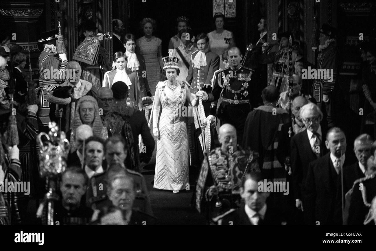 Tenendo le mani, la Regina e il Duca di Edimburgo in processione passando attraverso la Galleria reale del Palazzo di Westminster sulla strada per la Camera della Camera dei Lord per l'apertura di Stato del Parlamento. Camminando dietro le pagine d'onore, la principessa Anna. Il dignitario adirato a sinistra è il Signore Alto Cancelliere, il Signore Elwyn-Jones. Primo piano destra è il Signore presidente del Consiglio, il piede di Michael di Rt Hon. Foto Stock
