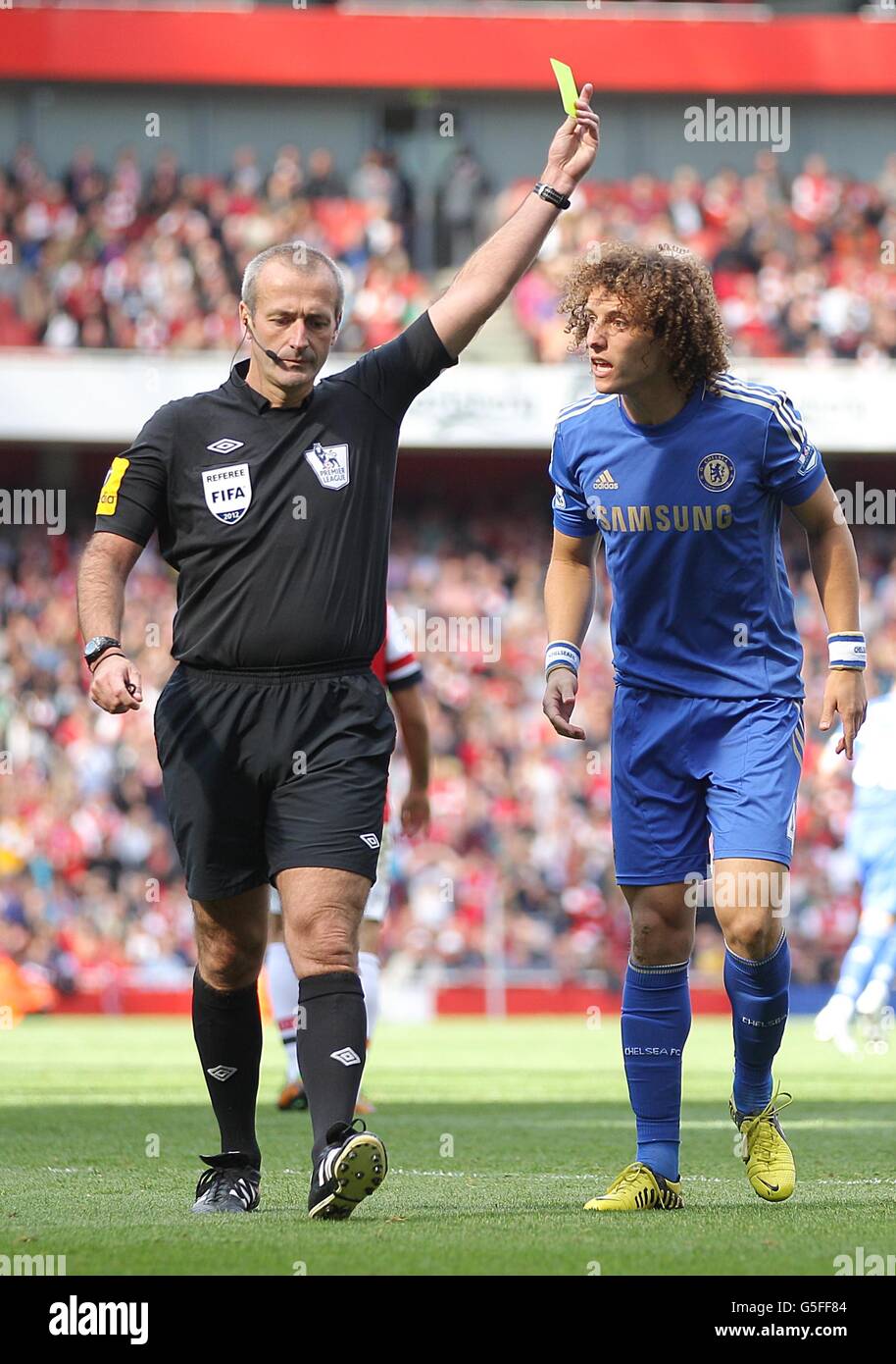 Calcio - Barclays Premier League - Arsenal / Chelsea - Emirates Stadium. L'arbitro Martin Atkinson mostra a David Luiz di Chelsea una carta gialla mentre Luiz protesta la sua innocenza Foto Stock