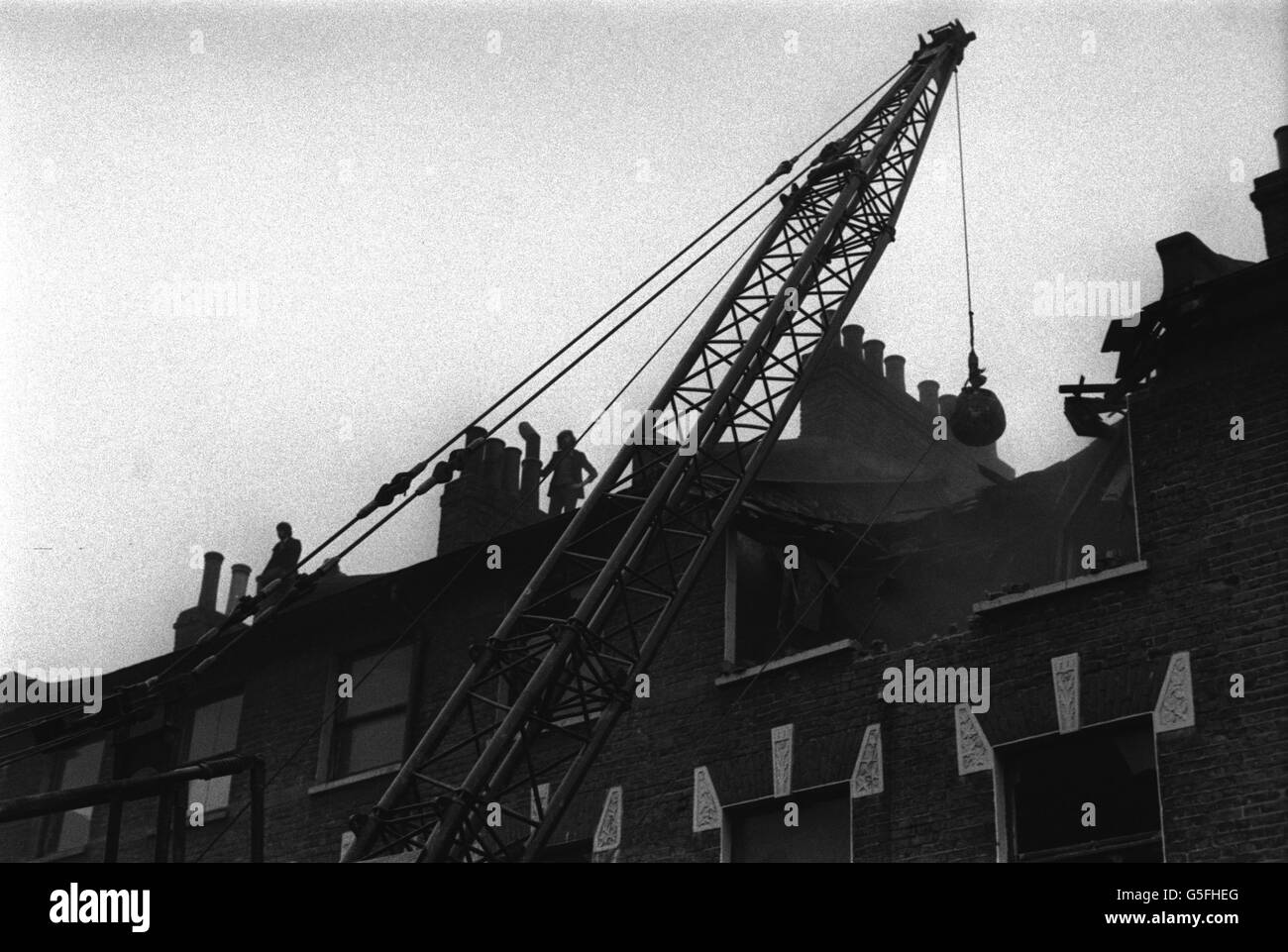 Gli squadratori guardano da un tetto vicino mentre un equipaggio di demolizione nt di Lambeth Council si sposta in St Agnes Place, per rendere le case vuote inabitabili. Foto Stock
