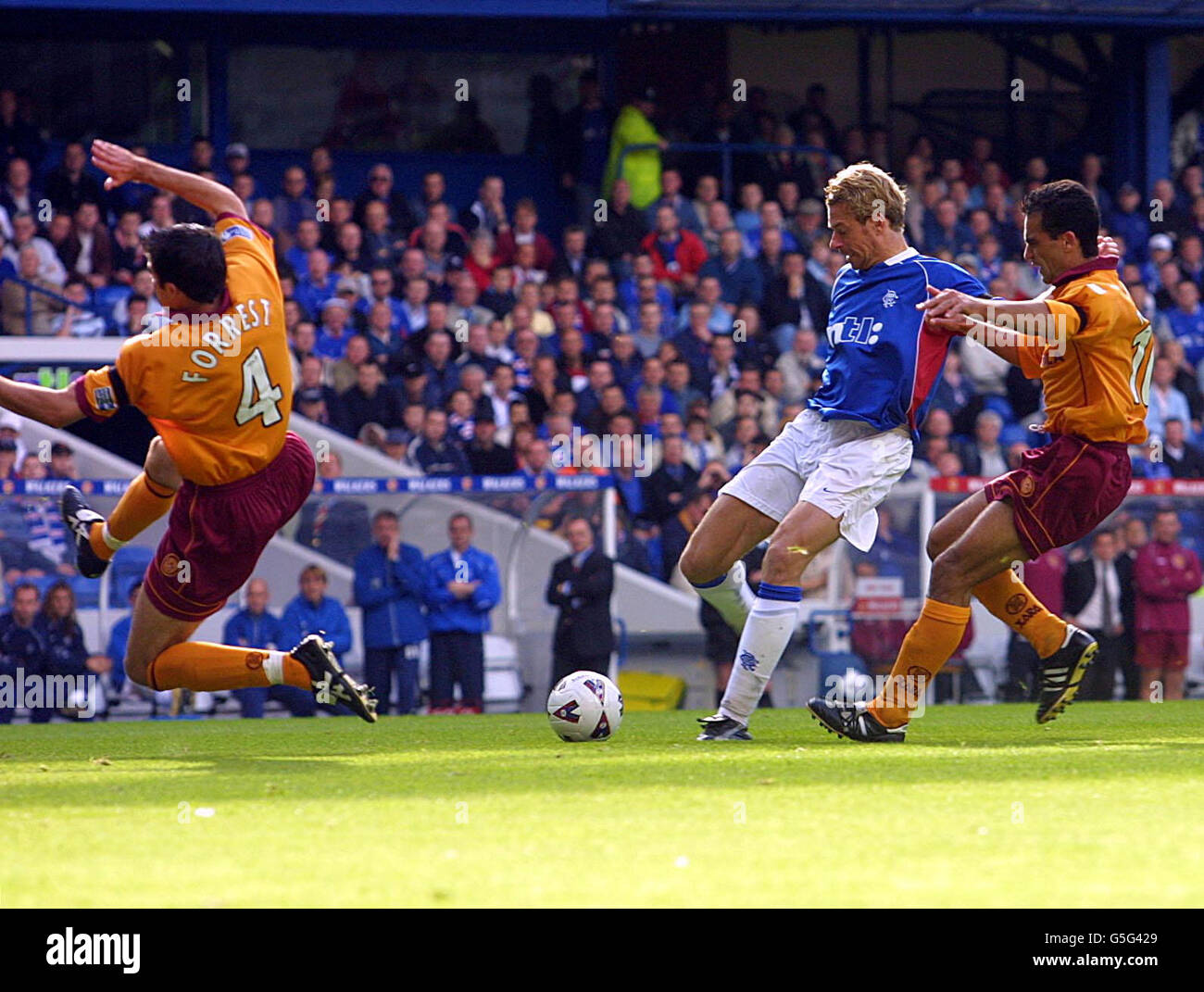 Motherwell's Eddie Forest (a sinistra) cerca di bloccare un colpo da Bert Konterman di Ranger durante la partita della Bank of Scotland Scottish Premier League tra Rangers e Motherwell a Ibrox, Glasgow. Foto Stock