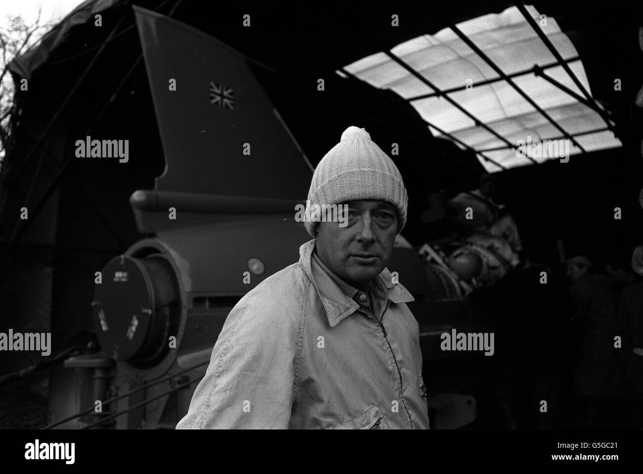 DONALD CAMPBELL 1966: Aspettando pazientemente ma desideroso di iniziare è Donald Campbell, ben avvolto contro il freddo, compreso un caldo cappello di lana, a Coniston. In background è il suo motoscafo Bluebird, essendo preparato per la sua offerta mondiale di velocità acqua su acqua Coniston. Foto Stock