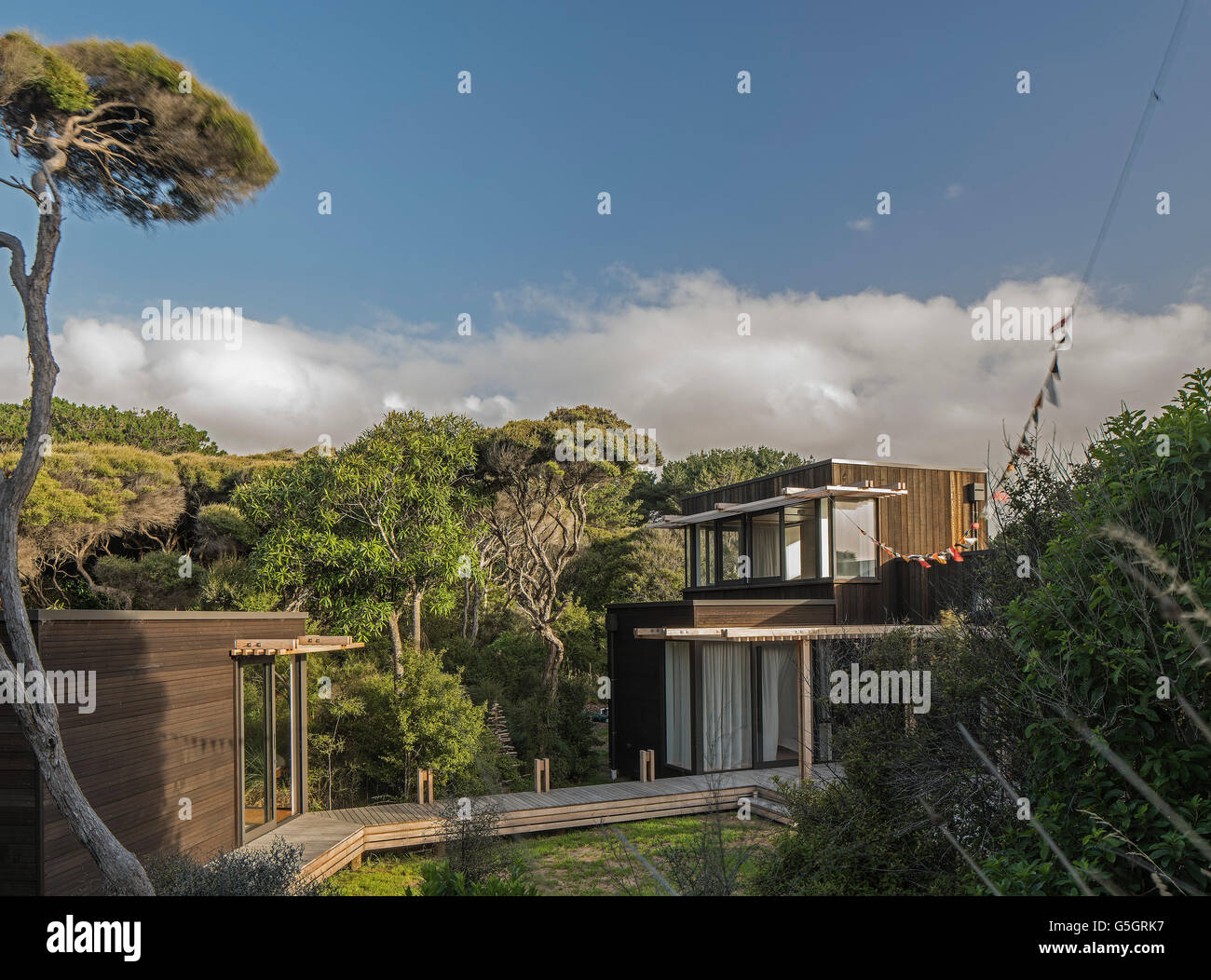 Colpo di casa da giardino con la macchia nativa, manuka tree e dormire fuori. La PEKA PEKA II HOUSE, Peka Peka - La Costa di Kapiti, Nuova Zelanda. Architetto: HMA, 2016. Foto Stock