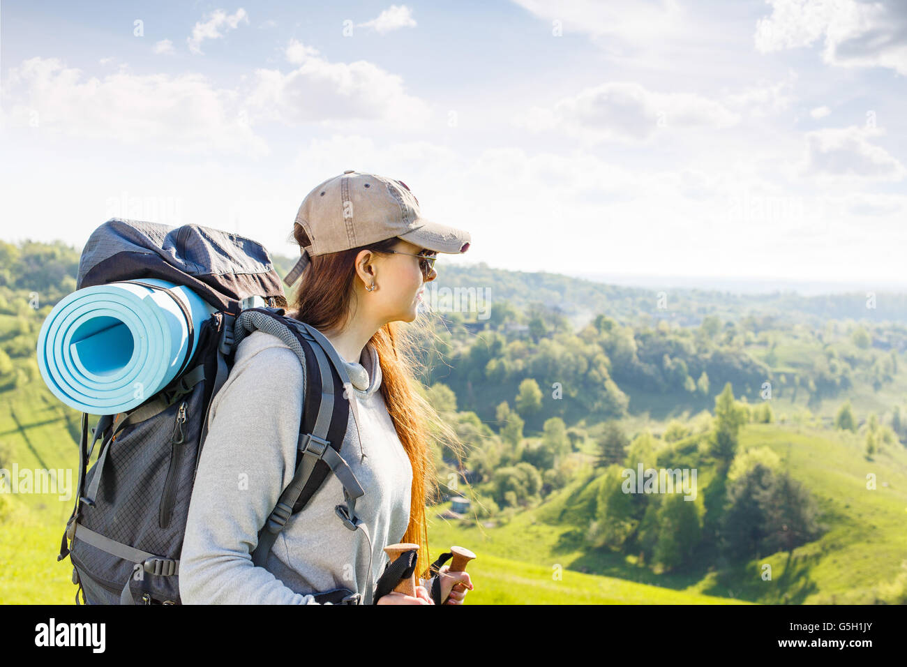 Giovane donna trekking con zaino e pali godendo bellissima scena della natura Foto Stock