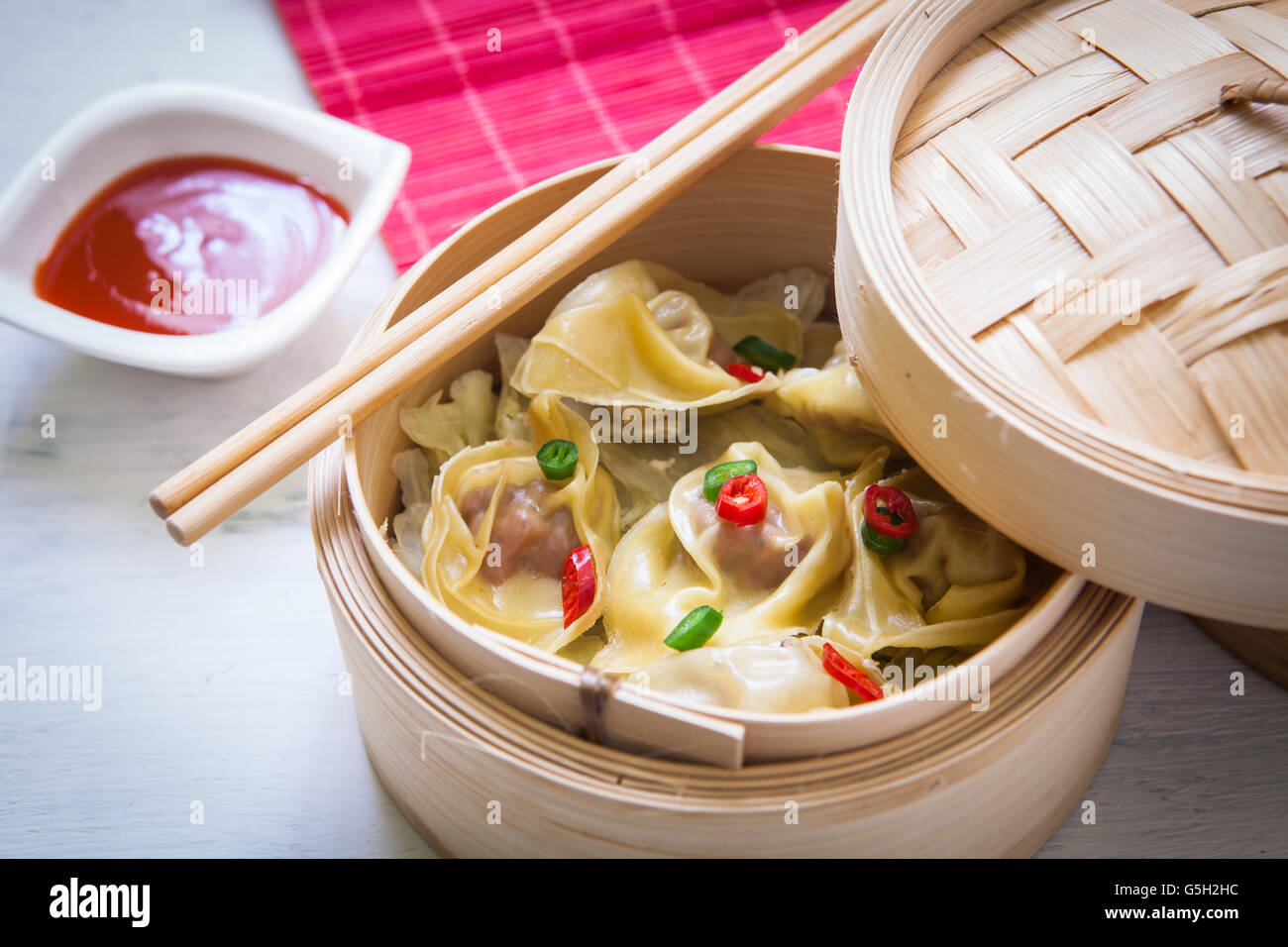 Al vapore dimsum cinese sul sistema di cottura a vapore con salsa agrodolce Foto Stock