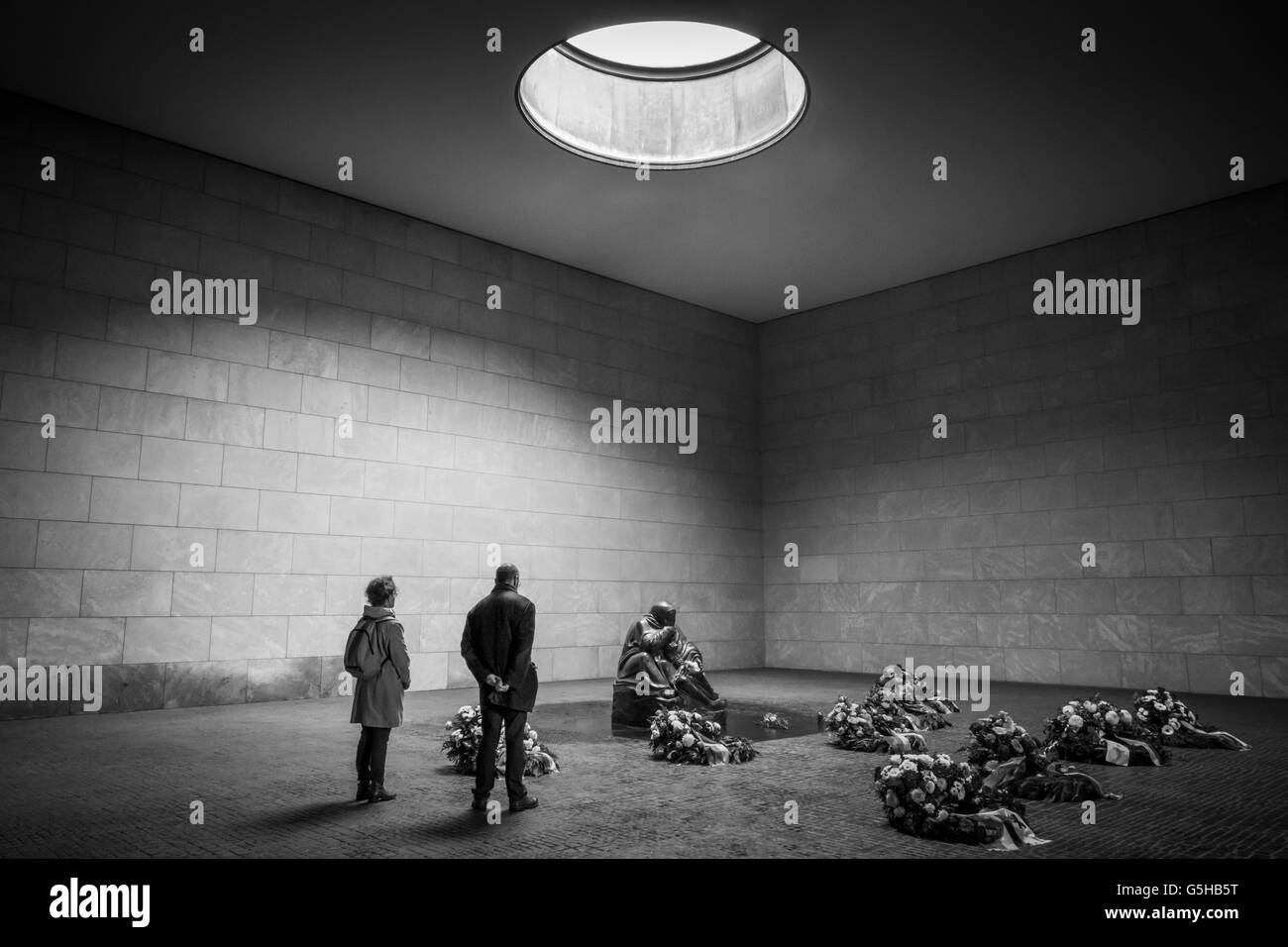 Un paio di pagare i loro resects tra omaggi floreali presso la War Memorial presso la Neue Wache di Berlino, Germania Foto Stock