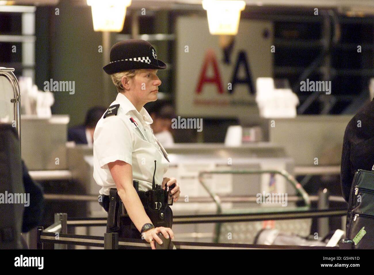 Polizia presso il banco di check-in American Airlines al Terminal 3 dell'aeroporto di Heathrow, a seguito del disastro aereo a New York. Più di 250 persone sono state temute uccise dopo che un volo Airbus A-300 587 si è schiantato nelle case nel distretto di Queens. Foto Stock
