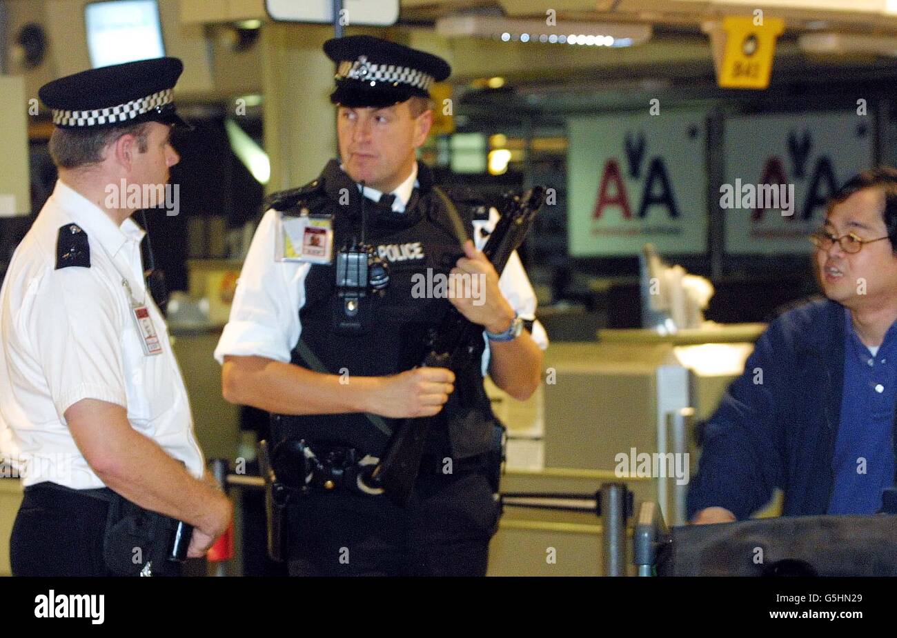 Polizia presso il banco di check-in American Airlines al Terminal 3 dell'aeroporto di Heathrow, a seguito del disastro aereo a New York. Più di 250 persone sono state temute uccise dopo che un volo Airbus A-300 587 si è schiantato nelle case nel distretto di Queens. Foto Stock