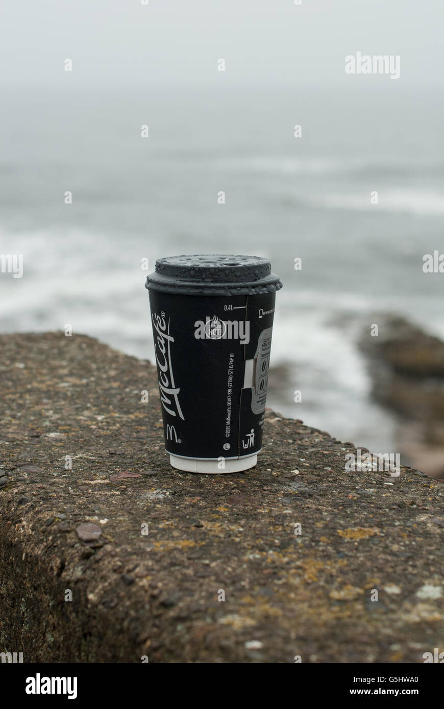 Concetto di immagine del British summertime in umido e nuvoloso meteo, mostrando una attenzione calda tazza di caffè con le gocce di pioggia Foto Stock