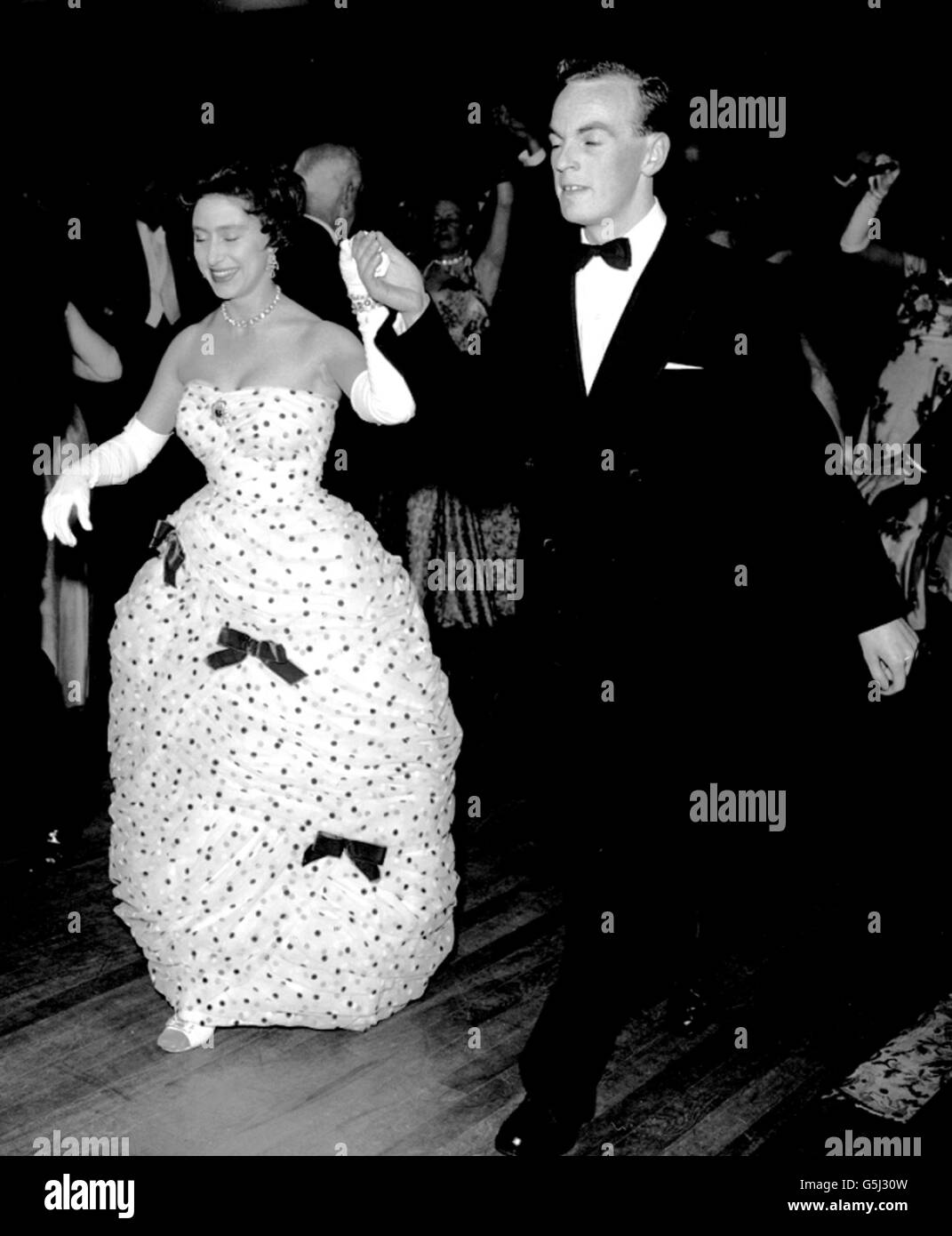 La principessa Margaret, che ha una tradizionale misura con Jackie Toaduff, nel 'Portland Fancy', una maschera, alla palla data dalla Società di canto e di Danza Folcloristica Inglese a Cecil Sharp House, Regent's Park Road, Londra. La principessa si vede indossare un abito a chiocciolato con bordo di palloncino decorato con archi. Foto Stock