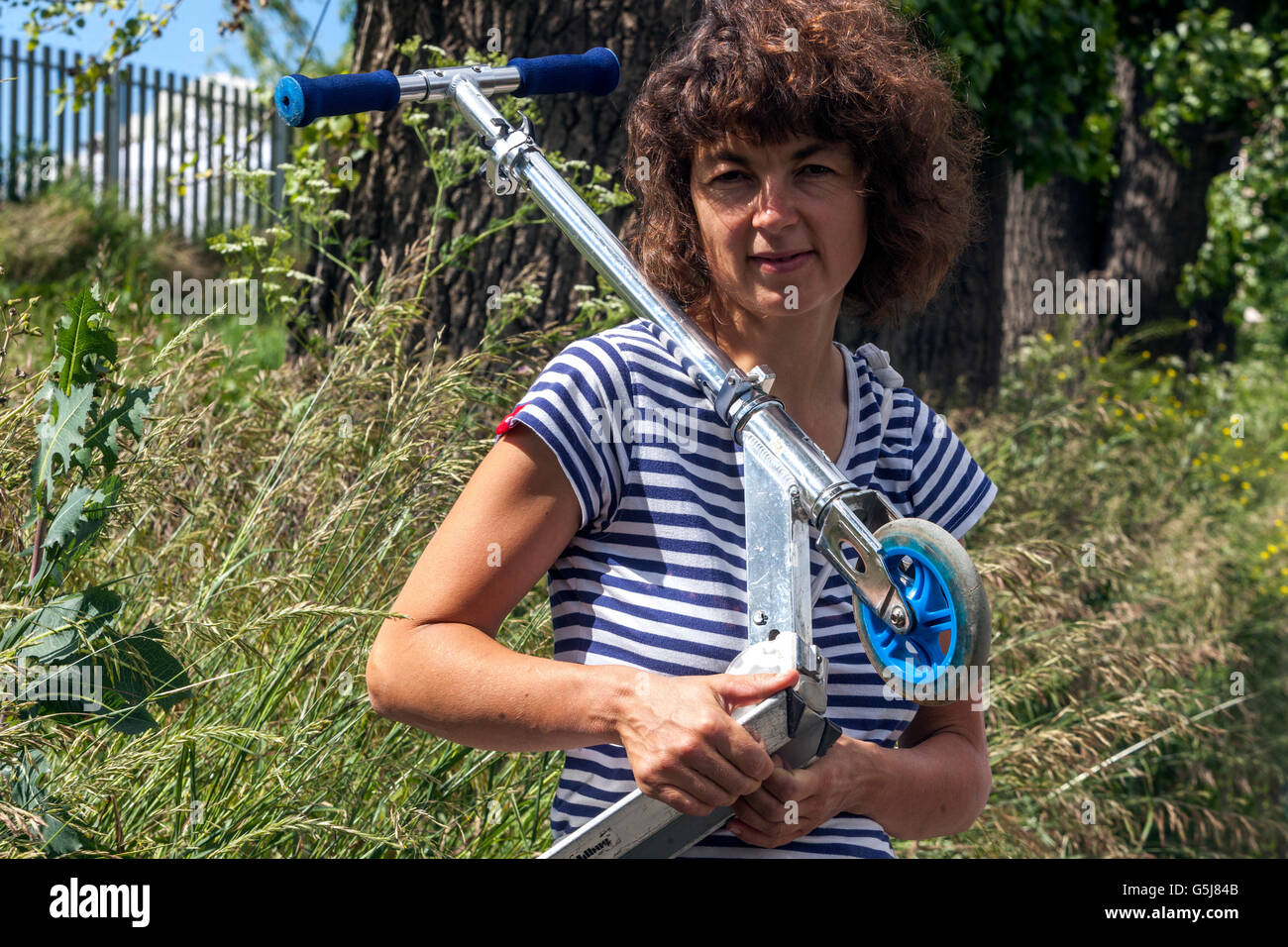 Donna con un'attività sportiva in scooter a spinta Foto Stock