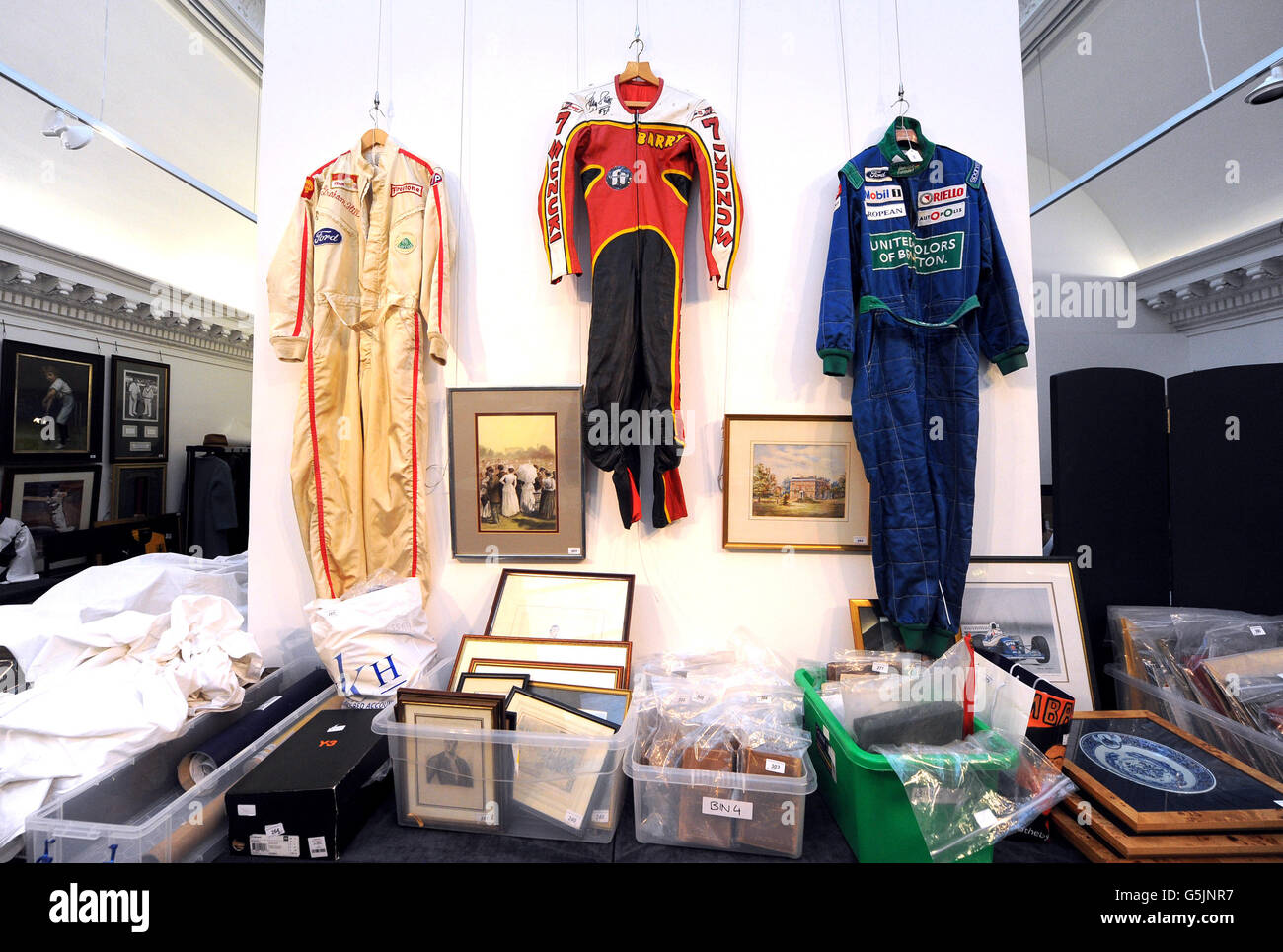 Le tute da pilota di Formula uno vengono esposte prima di un'asta di cimeli sportivi a Sotheby's, Londra. Foto Stock