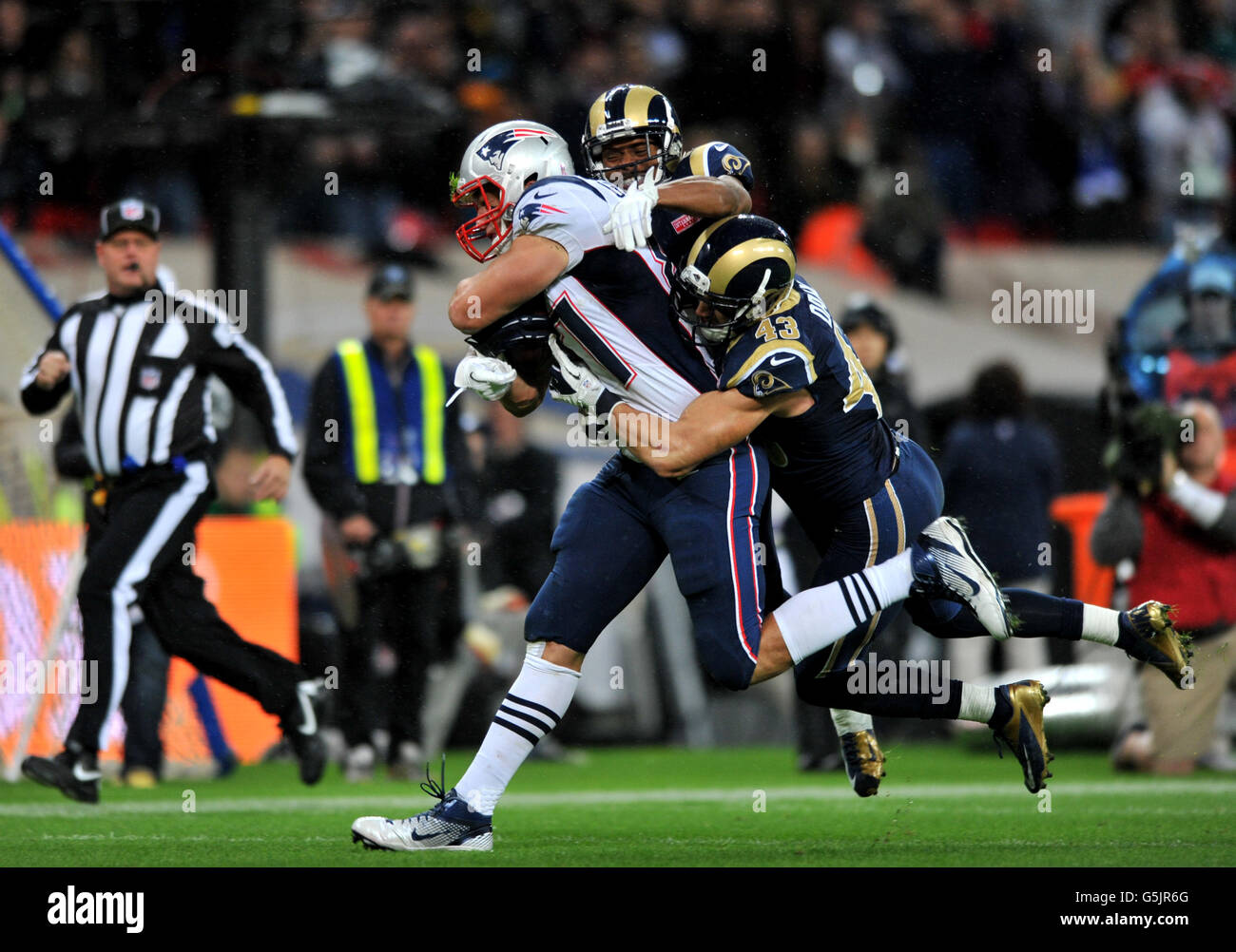 New England Patriots Rob Gronkoswki è affrontato da Craig Dahl di St Louis RAM durante la partita della NFL International Series allo stadio di Wembley, Londra. Foto Stock