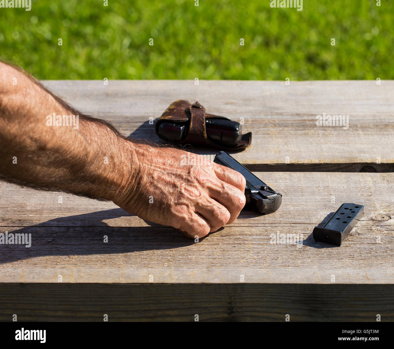 Vecchia persona sta toccando una pistola. Foto Stock