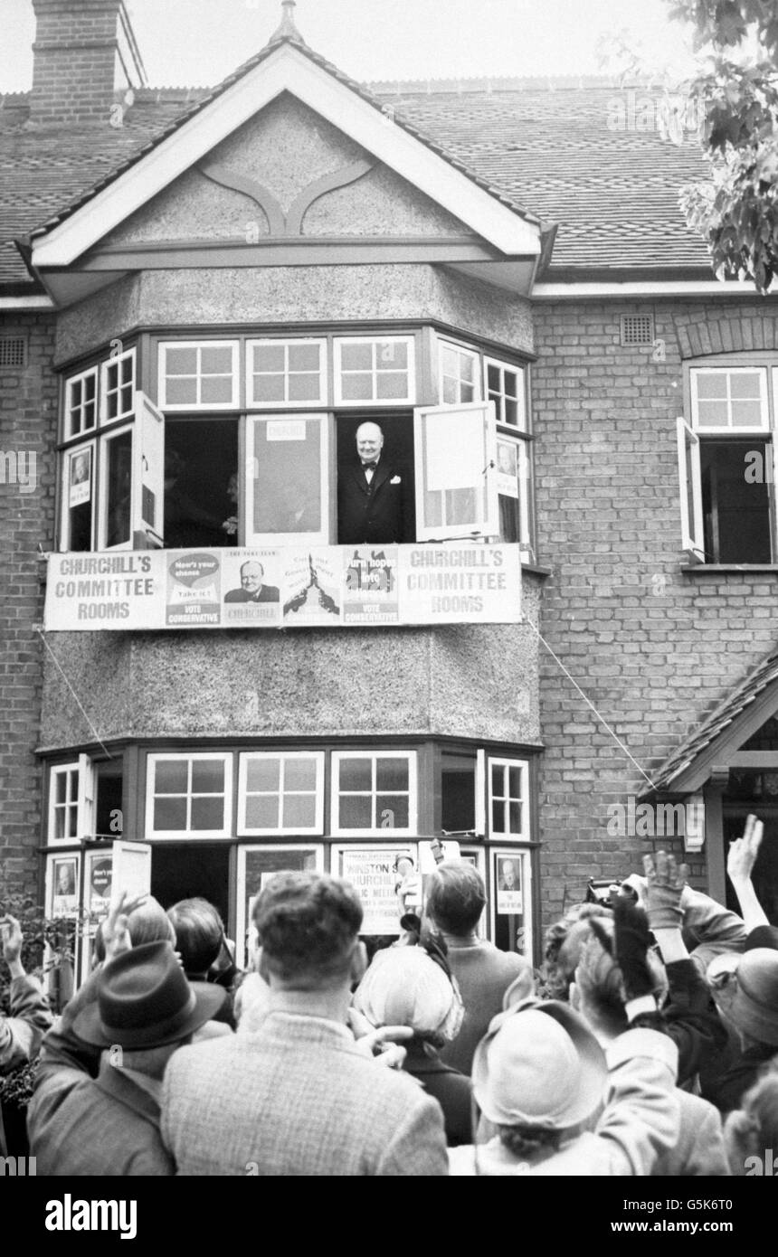 Winston Churchill sorride ad una folla giubilante da una finestra superiore delle sue sale centrali a Woodford, Essex. Foto Stock