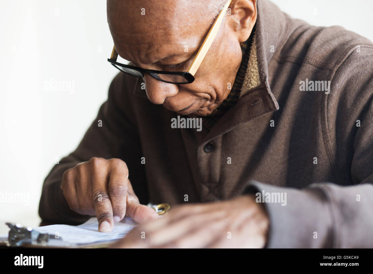 Vecchio Uomo nero lettura delle note Foto Stock