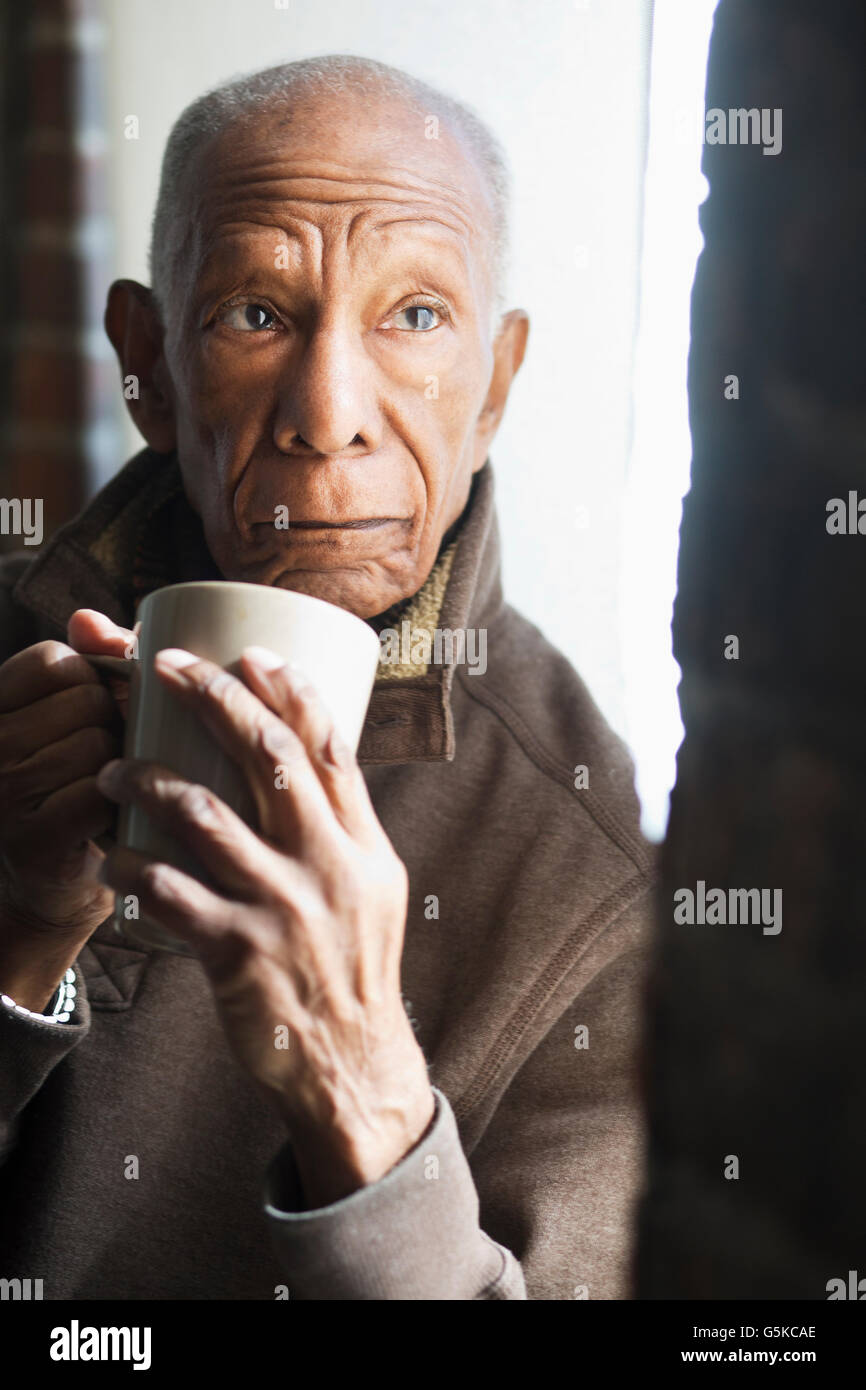 Vecchio Uomo nero bere tazza di caffè Foto Stock