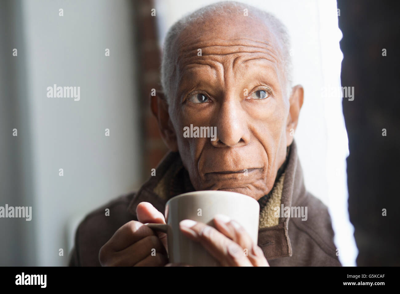 Vecchio Uomo nero bere tazza di caffè Foto Stock