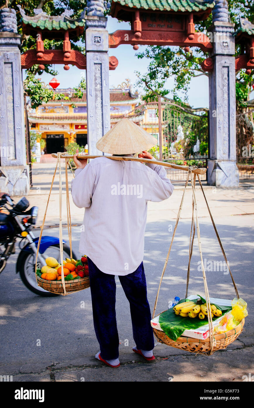 Il fornitore che trasportano cesti di frutta sul marciapiede della città Foto Stock
