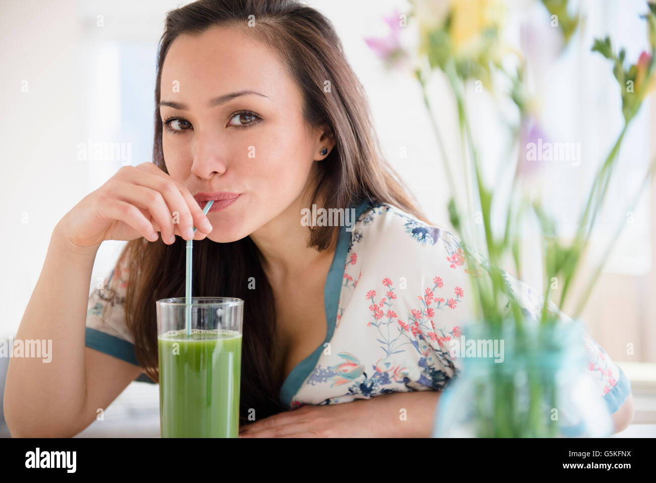 Donna di bere succo verde Foto Stock