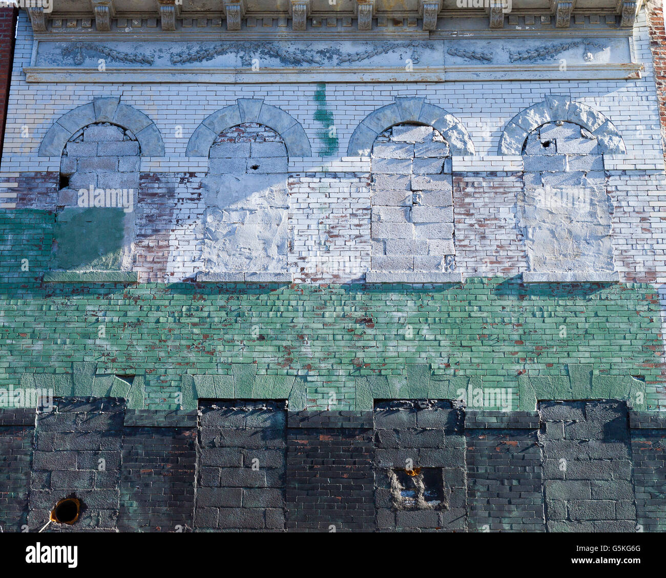 Imbarcati su Windows di un mattone di edificio industriale di Brooklyn dipinte di bianco, verde e grigio Foto Stock