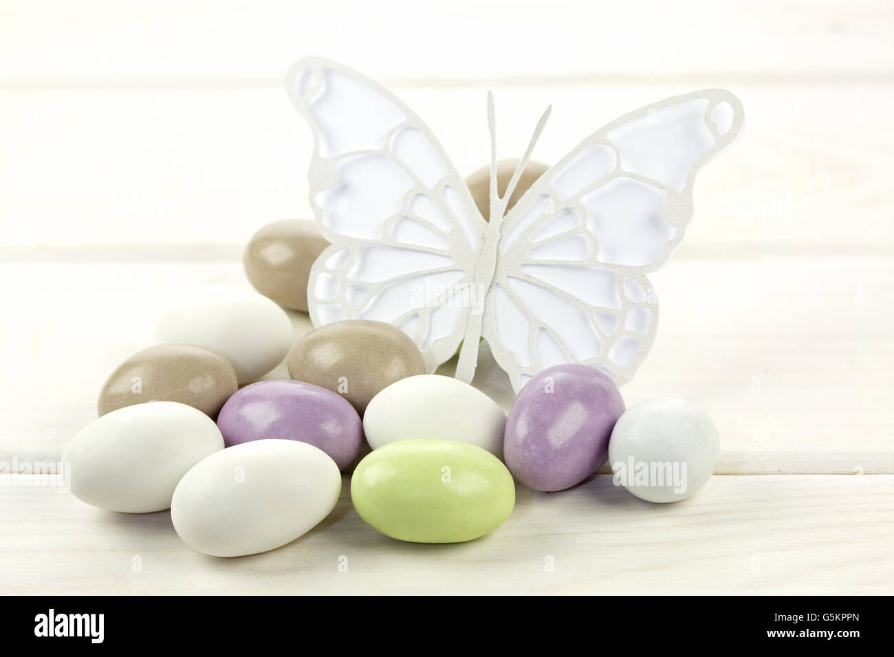 Colorato confetti e cartaceo sulla farfalla bianco sullo sfondo di legno Foto Stock