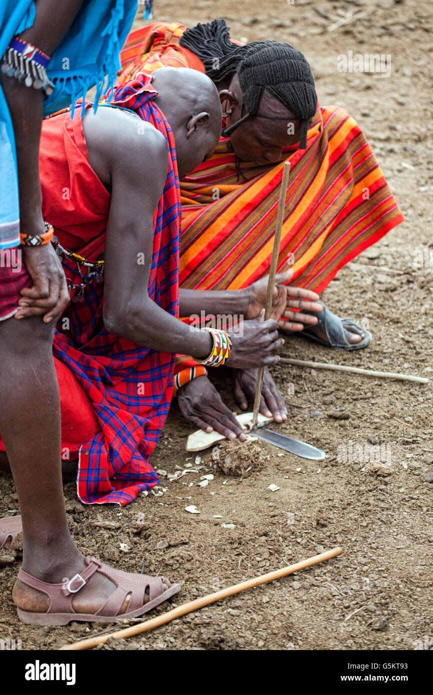 Un gruppo di giovani guerrieri Masai innescando un incendio nel villaggio dei masai in Kenya, Africa. Foto Stock